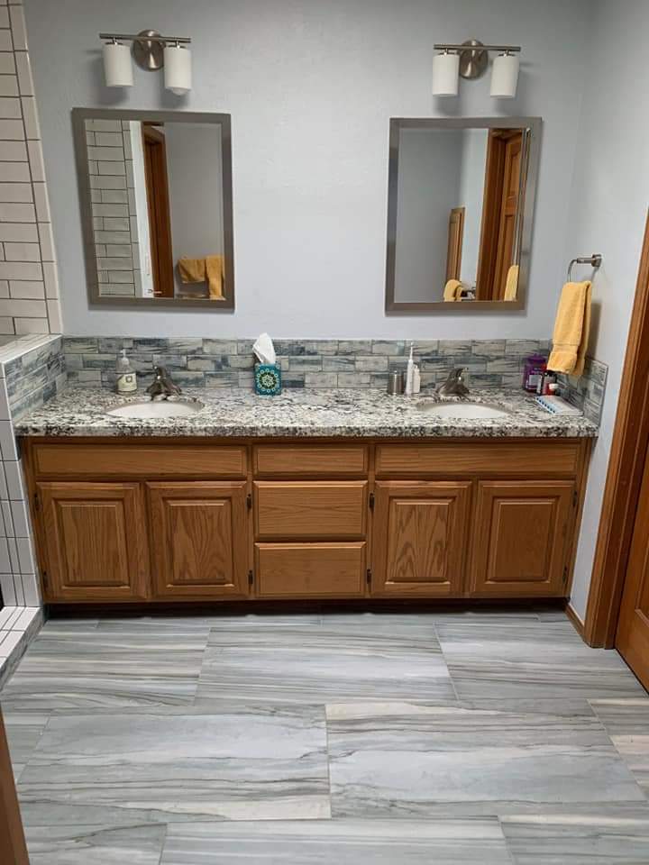 A bathroom with two sinks and a large mirror