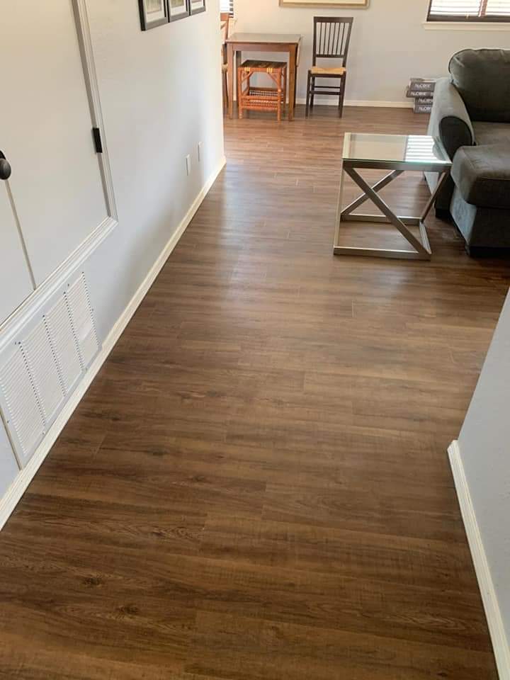 A living room with hard wood floors and white walls