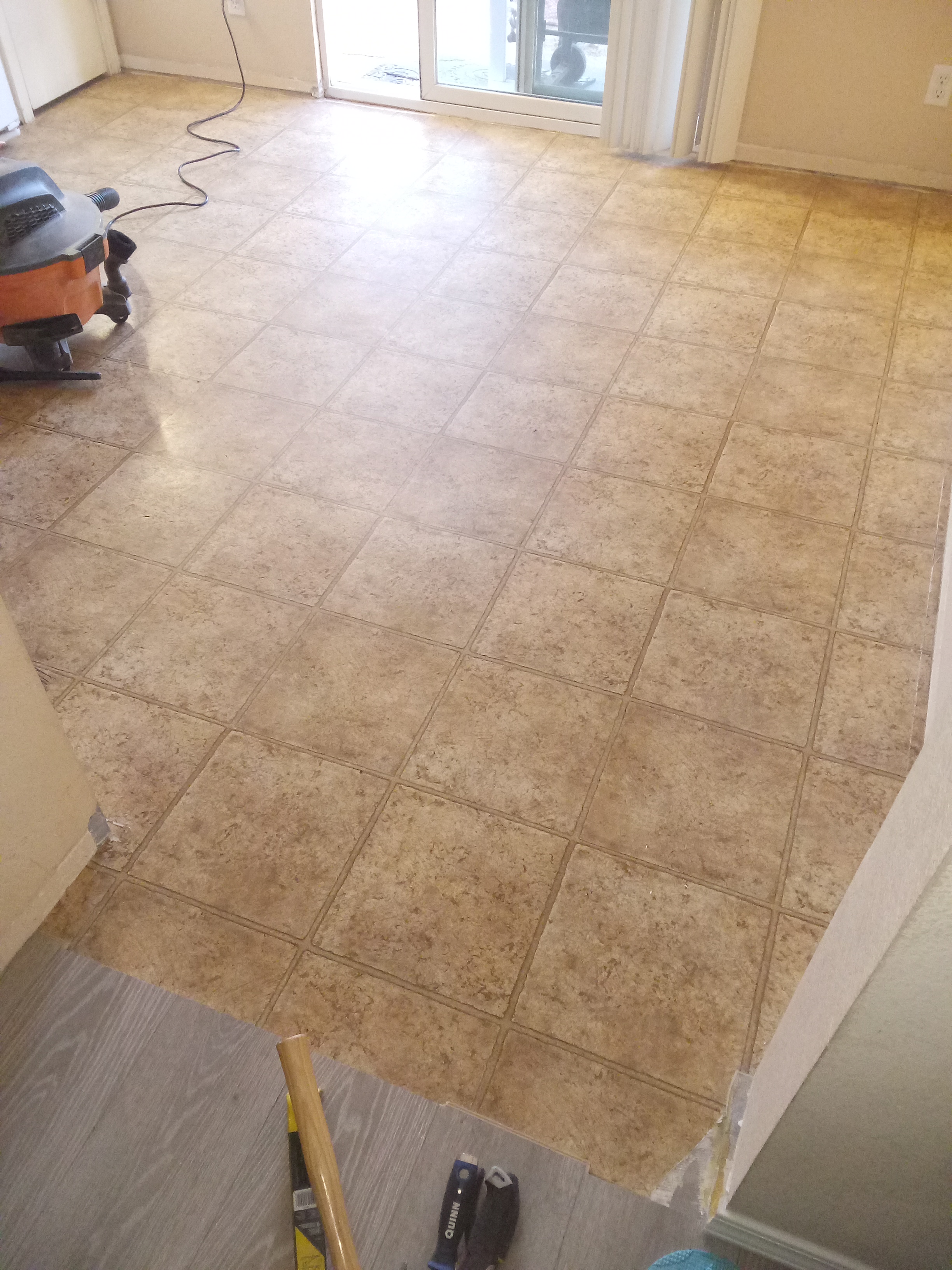 A room with a tile floor and a vacuum on the floor