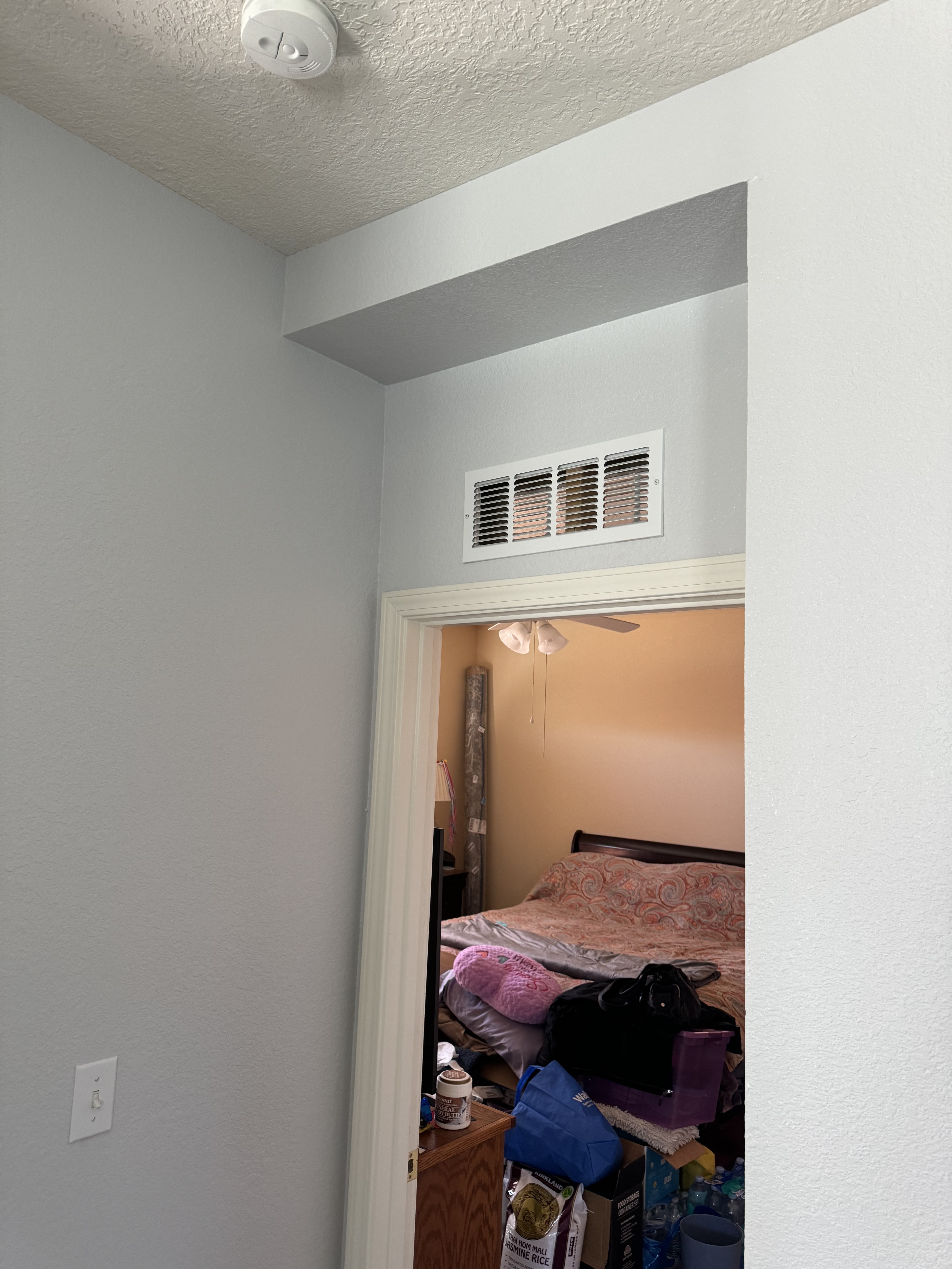 A room with a bed and a fan on the ceiling