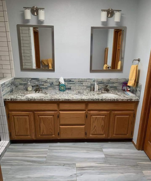 A bathroom with two sinks and two mirrors